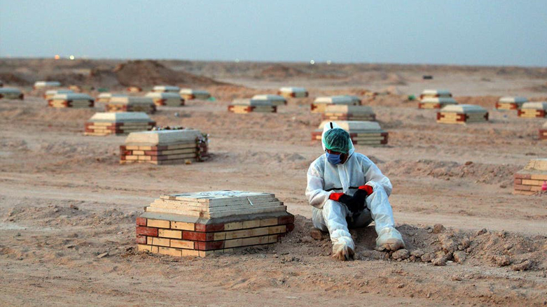 A man mourns over a tombstone at a cemetery for Covid-19 victims, 20km from the central Iraqi holy city of Najaf. (Photo: AFP)